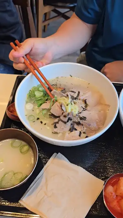 젓가락으로 전복 고기 국수를 집어 올리는 모습