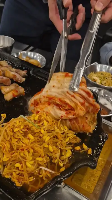 김치를 먹기 좋게 가위로 자르는 모습