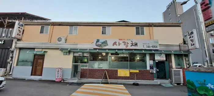 사랑채 식당 외부 모습, 깔끔한 간판과 함께 단정하게 정돈된 모습
