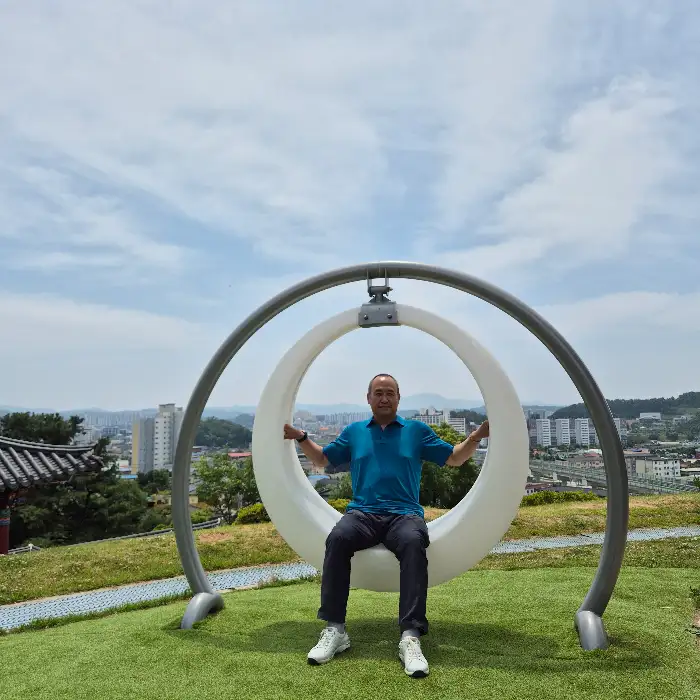 영주시 풍경을 배경으로 둥근 그네 의자에 앉아 있는 사람