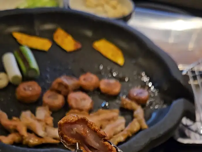 연막창 사상점에서 구워지는 윤기 나는 막창과 곁들임 채소