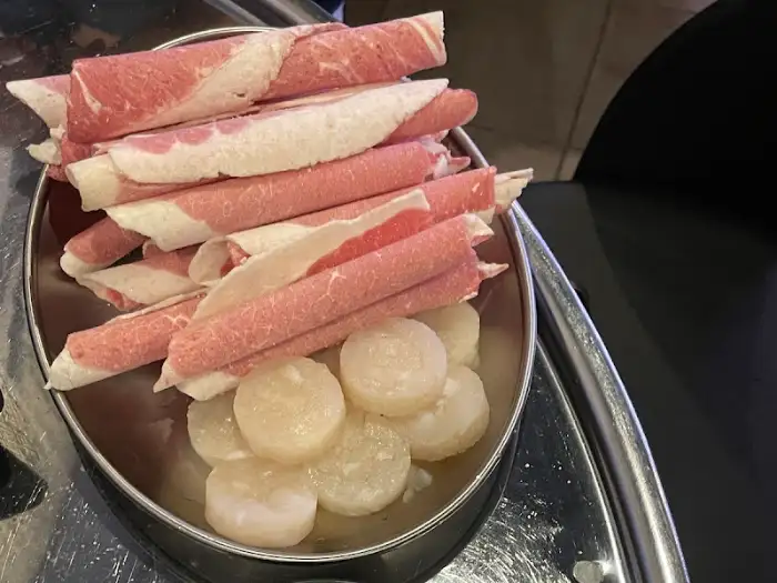 신선한 상태로 제공되는 얇게 썬 고기 롤과 동그란 떡