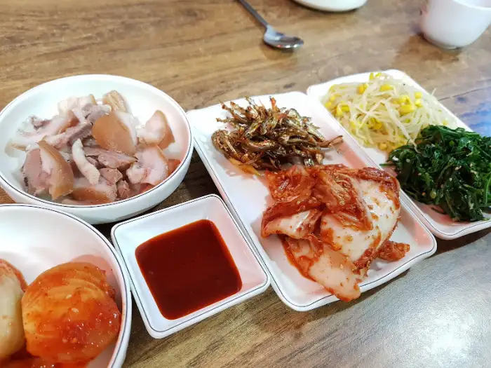 다양한 반찬과 함께 차려진 푸짐한 수육 한 접시